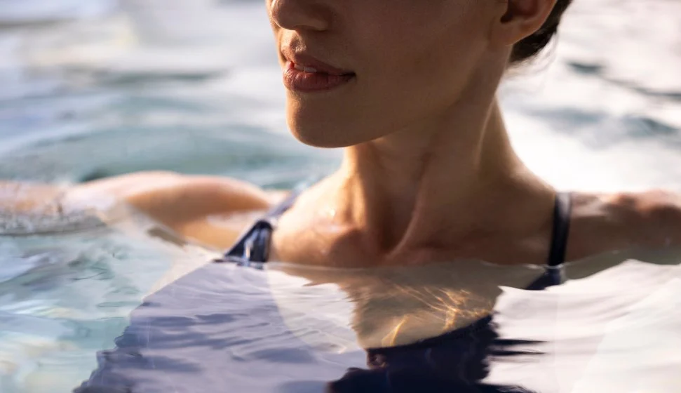 true water® system Woman relaxing in pool at sunset